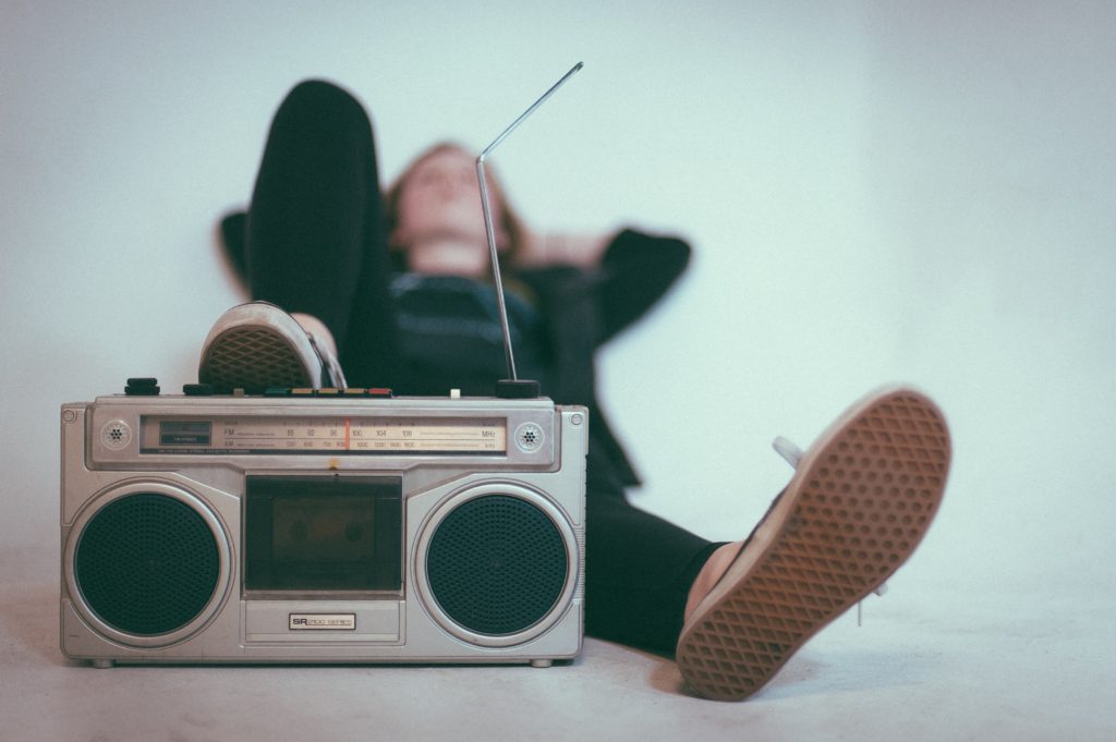 Person lying down and listening to the music from a boombox